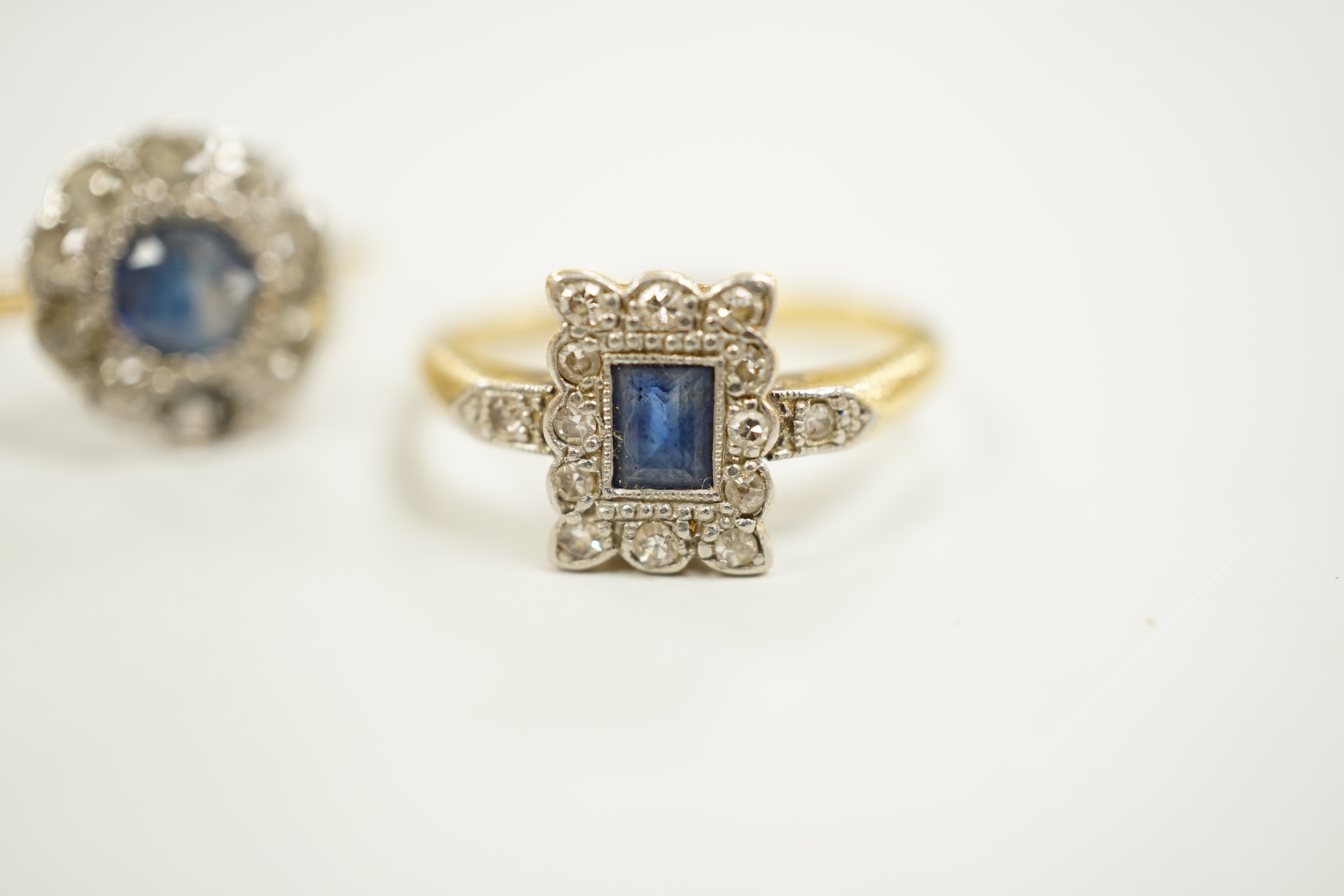 Two 1920's 18ct, sapphire and diamond cluster set dress rings, (one with misshapen shank and missing a diamond), gross weight 6.1 grams.